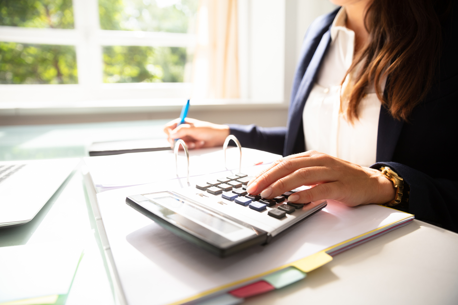 Woman Tapping on a Calculator 